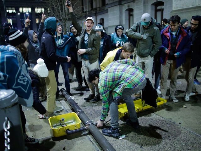 PHILADELPHIA, PA - FEBRUARY 04: People break a traffic light while celebrating the Philadelphia Eagles' victory in Super Bowl LII game against the New England Patriots on February 4, 2018 in Philadelphia, Pennsylvania..