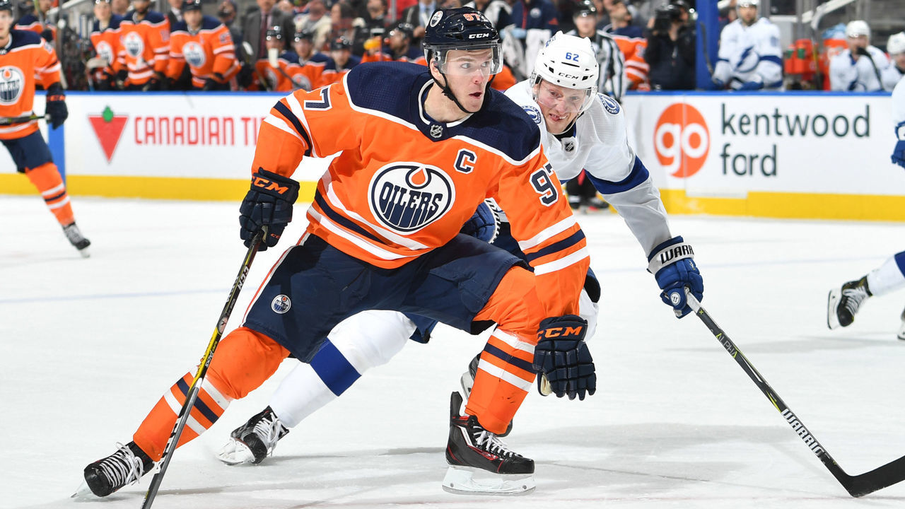 EDMONTON, AB - FEBRUARY 5: Connor McDavid #97 of the Edmonton Oilers skates with the puck while being pursued by Andrej Sustr #62 of the Tampa Bay Lightning on February 5, 2018 at Rogers Place in Edmonton, Alberta, Canada.