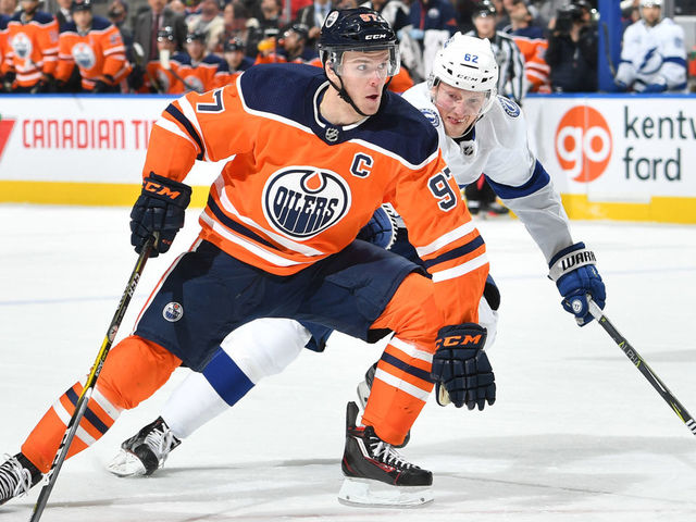EDMONTON, AB - FEBRUARY 5: Connor McDavid #97 of the Edmonton Oilers skates with the puck while being pursued by Andrej Sustr #62 of the Tampa Bay Lightning on February 5, 2018 at Rogers Place in Edmonton, Alberta, Canada.