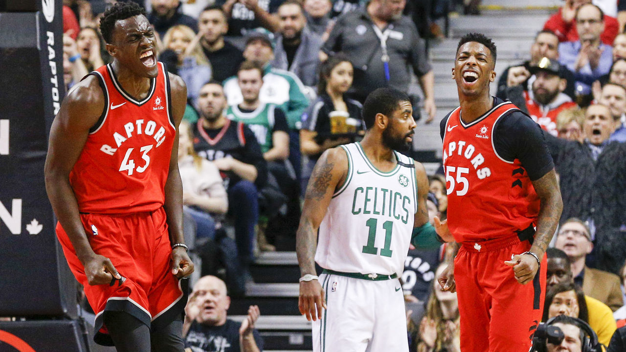 TORONTO, ON - FEBRUARY 6 - Delon Wright (55) of the Raptors reacts after he threw an alley oop to Pascal Siakam (43) with Kyrie Irving (11) of the Celtics in the background during the 1st half of NBA action as the Toronto Raptors host the Boston Celtics at the Air Canada Centre on February 6, 2018. (Carlos Osorio/Toronto Star via Getty Images)