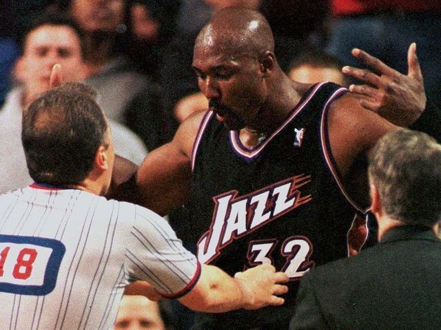 SEATTLE, UNITED STATES: Karl Malone (C) of the Utah Jazz argues with referee Mark Wunderlich (L) as Utah assistant coach Phil Johnson(R) approaches during game 4 of the first round of the Western Conference Playoffs, against the Seattle SuperSonics 03 May 2000 in Seattle. Seattle won the game 104-93, to even the series 2-2. AFP PHOTO DAN LEVINE