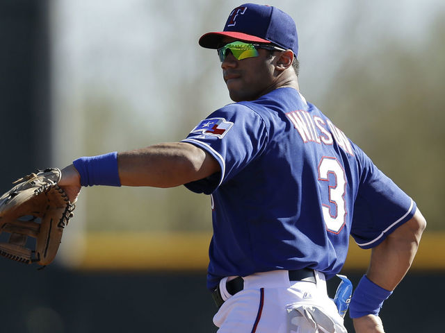 SURPRISE, AZ - MARCH 03: Russell Wilson #3 of the Texas Rangers throws in the outfield during a work out before the game against the Cleveland Indians at Surprise Stadium on March 03, 2014 in Surprise, Arizona.