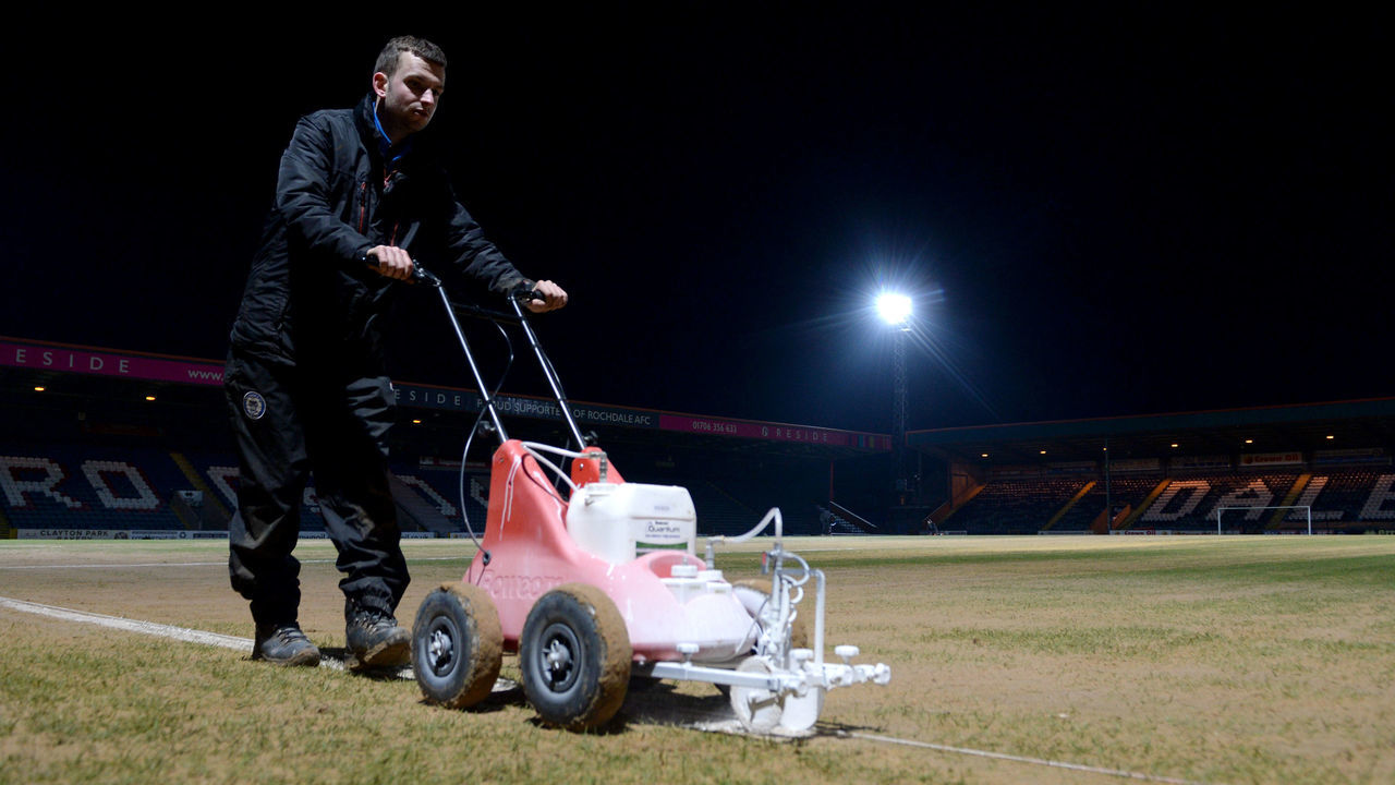 ROCHDALE, ENGLAND - FEBRUARY 06: Groundsmen paint the white lines prior to The Emirates FA Cup Fourth Round match between Rochdale AFC and Millwall at Spotland Stadium on February 6, 2018 in Rochdale, England.
