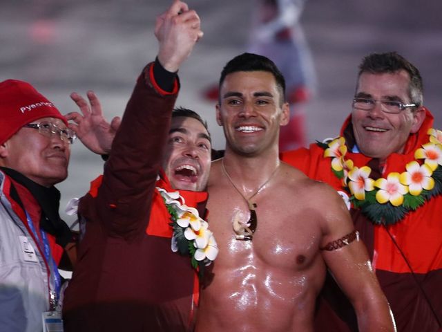 Tonga's flagbearer Pita Taufatofua (C-R) takes a selfie as his country's delegation parades during the opening ceremony of the Pyeongchang 2018 Winter Olympic Games at the Pyeongchang Stadium on February 9, 2018. / AFP PHOTO / POOL / -