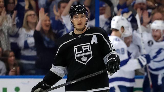TAMPA, FL - FEBRUARY 10: Dustin Brown #23 and Derek Forbort #24 of the Los Angeles Kings react as members of the Tampa Bay Lightning celebrate a goal at the Amalie Arena on February 10, 2018 in Tampa, Florida.