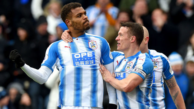 HUDDERSFIELD, ENGLAND - FEBRUARY 11: Steve Mounie of Huddersfield Town celebrates with teammate Jonathan Hogg after scoring his sides third goal during the Premier League match between Huddersfield Town and AFC Bournemouth at John Smith's Stadium on February 11, 2018 in Huddersfield, England.