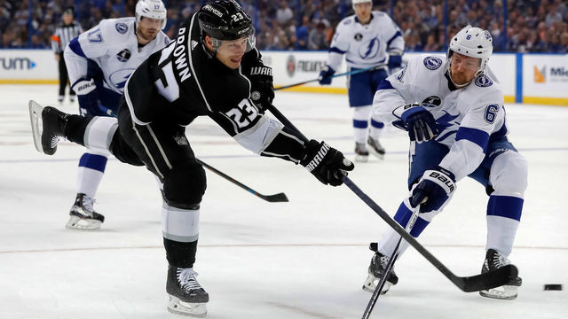 TAMPA, FL - FEBRUARY 10: Dustin Brown #23 of the Los Angeles Kings shoots past Anton Stralman #6 of the Tampa Bay Lightning at the Amalie Arena on February 10, 2018 in Tampa, Florida.
