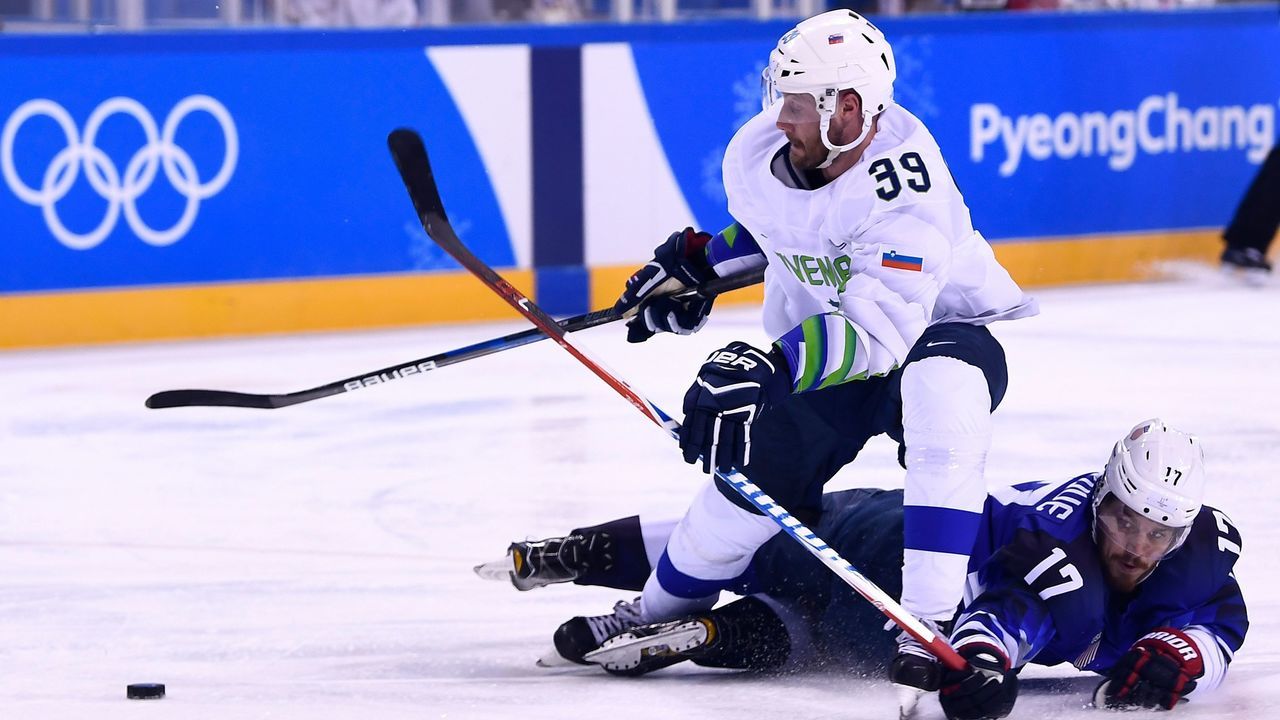 Slovenia's Jan Mursak vies with USA's Chris Bourque in the men's preliminary round ice hockey match between the US and Slovenia during the Pyeongchang 2018 Winter Olympic Games at the Kwandong Hockey Centre in Gangneung on February 14, 2018. / AFP PHOTO / Brendan Smialowski