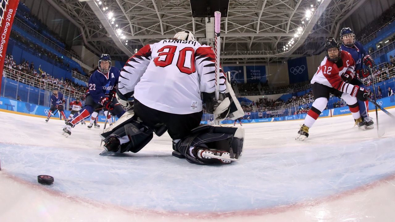 Japan's goalie Akane Konishi looks on as the puck sails past for a goal in the women's preliminary round ice hockey match between Japan and the Unified Korean team during the Pyeongchang 2018 Winter Olympic Games at the Kwandong Hockey Centre in Gangneung on February 14, 2018. / AFP PHOTO / POOL / Bruce Bennett
