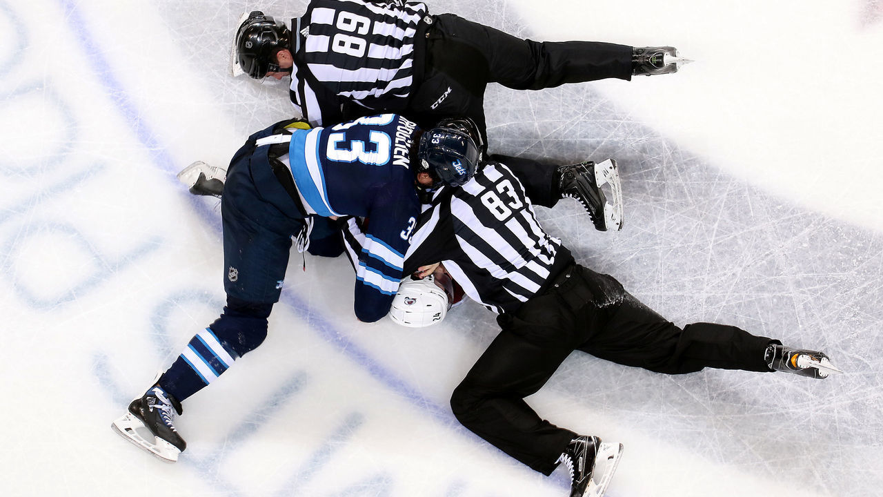 WINNIPEG, MB - FEBRUARY 16: Linesman Steve Miller #89 and Matt MacPherson #83 work to separate Dustin Byfuglien #33 of the Winnipeg Jets and A.J. Greer #24 of the Colorado Avalanche after a second period tilt at the Bell MTS Place on February 16, 2018 in Winnipeg, Manitoba, Canada.
