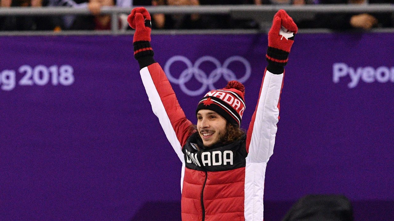 Canada's Samuel Girard celebrates on the podium for winning gold in the men's 1,000m short track speed skating venue ceremony during the Pyeongchang 2018 Winter Olympic Games, at the Gangneung Ice Arena in Gangneung on February 17, 2018. / AFP PHOTO / Mladen ANTONOV