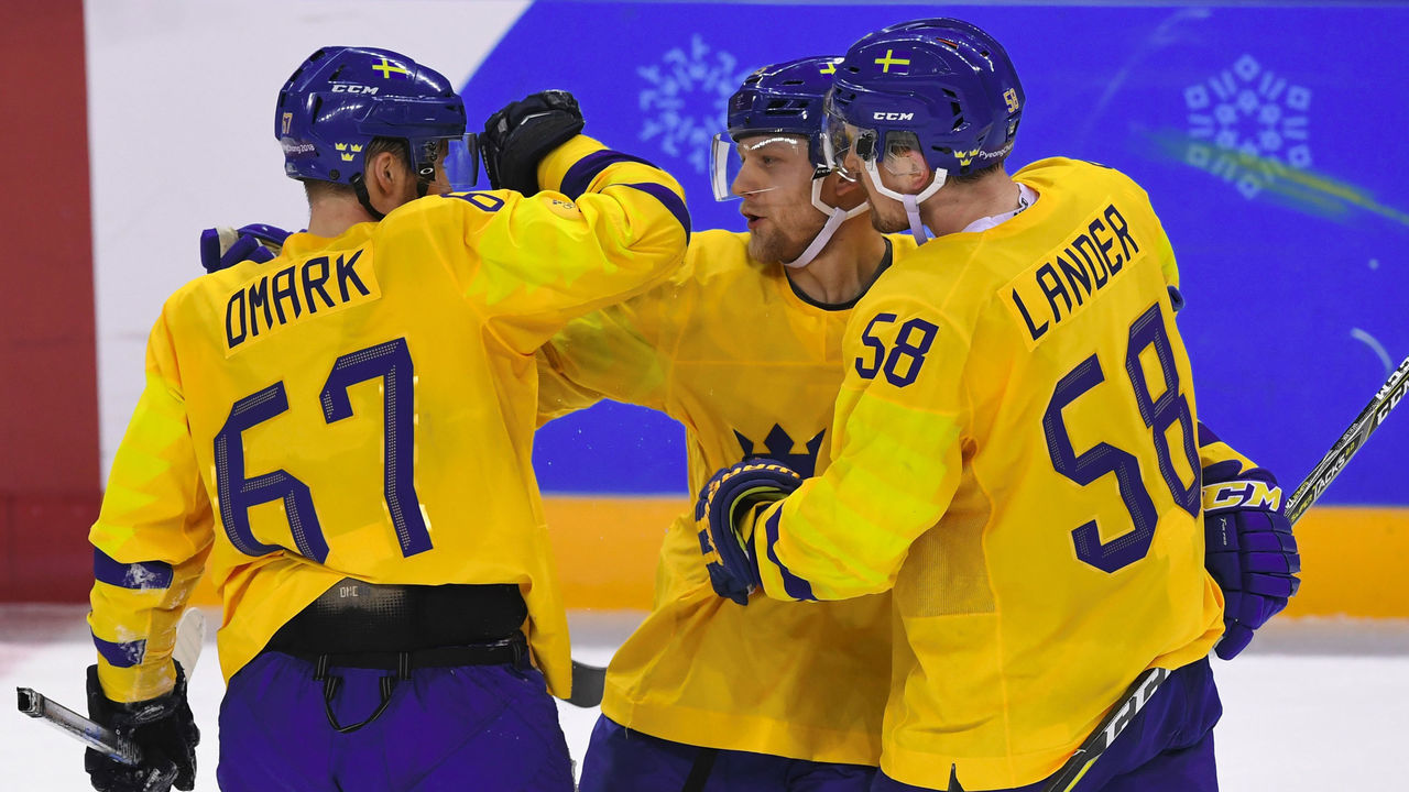 Sweden's Oscar Moller (C) celebrates scoring with teammates Linus Omark (L) and Anton Lander against Finland in the men's preliminary round ice hockey match between Sweden and Finland during the Pyeongchang 2018 Winter Olympic Games at the Kwandong Hockey Centre in Gangneung on February 18, 2018. / AFP PHOTO / Jung Yeon-je