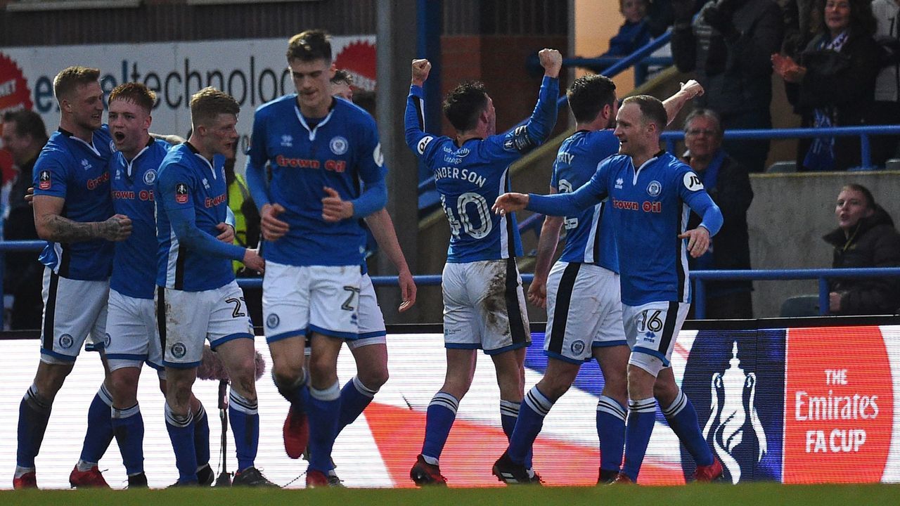 Rochdale's English striker Ian Henderson (C) celebrates with teammates after scoring the opening goal of the English FA Cup fifth round football match between Rochdale and Tottenham Hotspur at the Crown Oil Arena in Rochdale, north west England on February 18, 2018. / AFP PHOTO / Oli SCARFF /