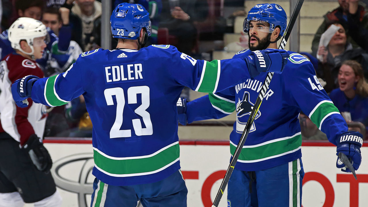 VANCOUVER, BC - FEBRUARY 20: Darren Archibald #49 of the Vancouver Canucks is congratulated by Alexander Edler #23 after scoring during their NHL game at Rogers Arena February 20, 2018 in Vancouver, British Columbia, Canada.