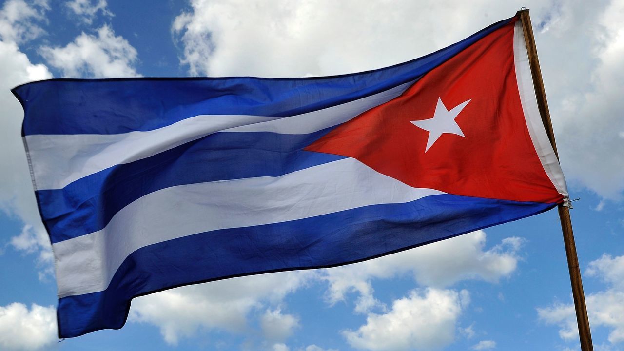 A person holds a Cuban national flag as Cubans arrive to pay their last respects to late revolutionary leader Fidel Castro at Revolution Square in Havana, on November 29, 2016. A titan of the 20th century who beat the odds to endure into the 21st, Castro died late Friday after surviving 11 US administrations and hundreds of assassination attempts. No cause of death was given. Castro's ashes will go on a four-day island-wide procession starting Wednesday before being buried in the southeastern city of Santiago de Cuba on December 4. / AFP / PEDRO PARDO