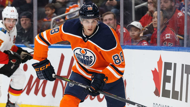 EDMONTON, AB - JANUARY 25: Brandon Davidson #88 of the Edmonton Oilers is pursued by Sean Monahan #23 of the Calgary Flames at Rogers Place on January 25, 2018 in Edmonton, Canada.