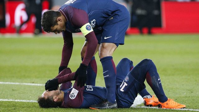 Paris Saint-Germain's Brazilian defender Thiago Silva (up) speaks to Paris Saint-Germain's Brazilian forward Neymar Jr lying on the pitch during the French L1 football match between Paris Saint-Germain (PSG) and Marseille (OM) at the Parc des Princes in Paris on February 25, 2018. / AFP PHOTO / GEOFFROY VAN DER HASSELT