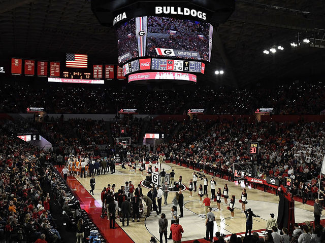 ATHENS, GA - FEBRUARY 17: Fans shine lights on their phones as a UGA flag is run onto the floor during a stoppage in play of the Tennessee Volunteers' basketball game against the Georgia Bulldogs at Stegeman Coliseum on February 17, 2018 in Athens, Georgia.