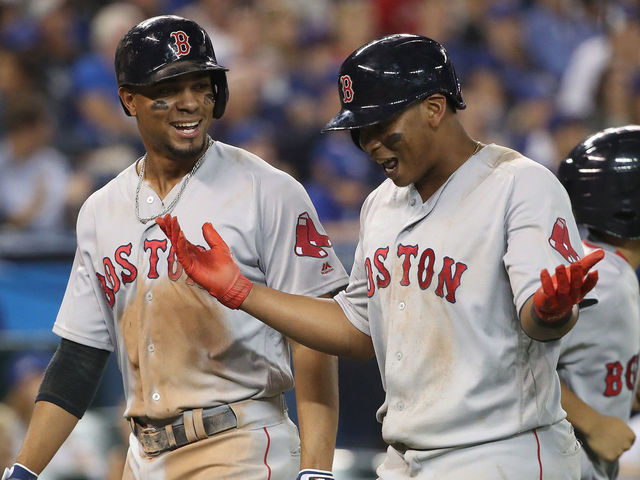TORONTO, ON - AUGUST 30: Xander Bogaerts #2 of the Boston Red Sox celebrates with Rafael Devers #11 after both scored on a single by Mitch Moreland in the eighth inning during MLB game action against the Toronto Blue Jays at Rogers Centre on August 30, 2017 in Toronto, Canada.