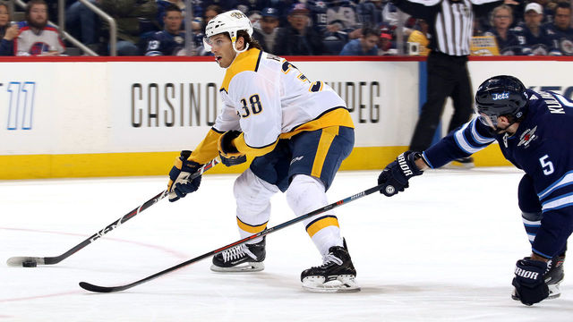 WINNIPEG, MB - FEBRUARY 27: Ryan Hartman #38 of the Nashville Predators plays the puck away from Dmitry Kulikov #5 of the Winnipeg Jets during first period action at the Bell MTS Place on February 27, 2018 in Winnipeg, Manitoba, Canada.