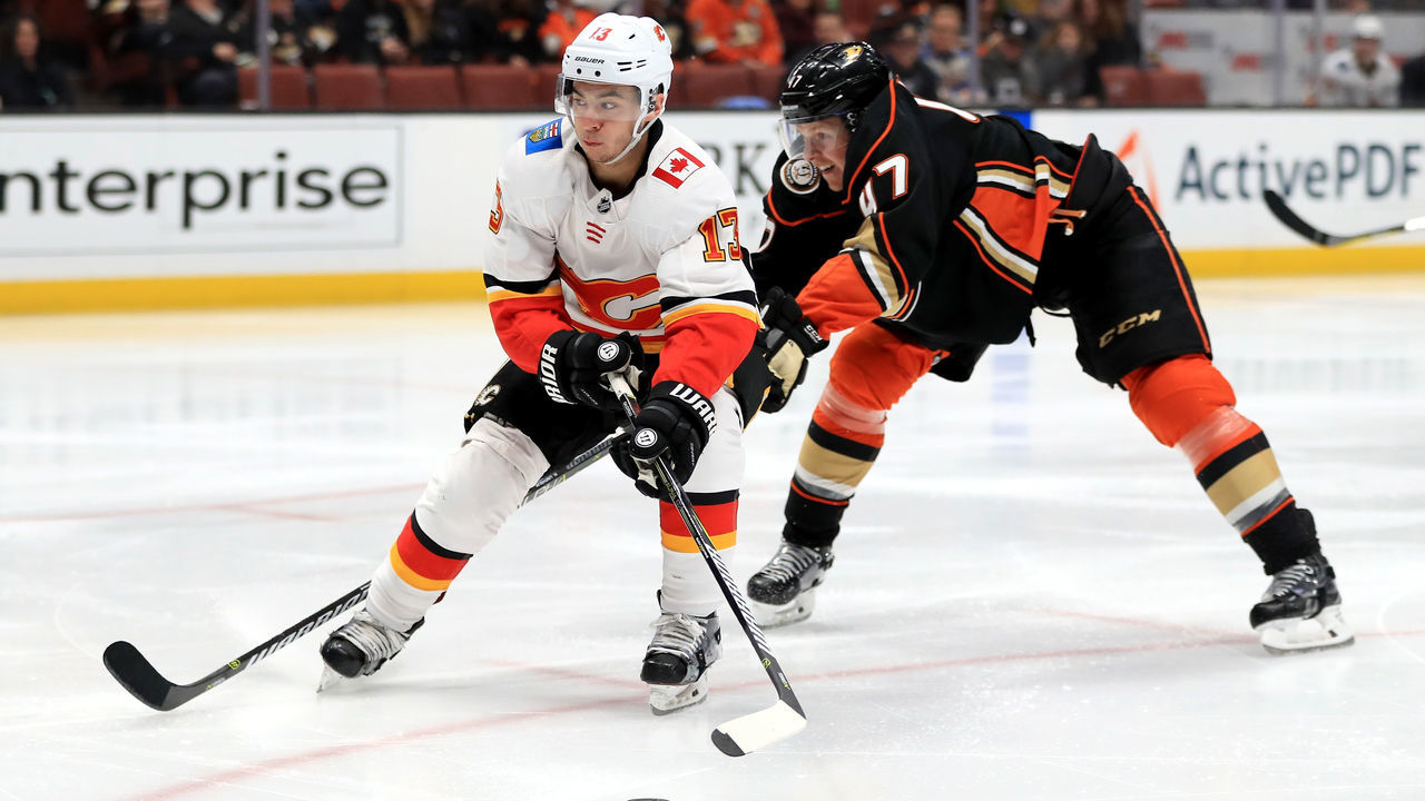 ANAHEIM, CA - DECEMBER 29: Johnny Gaudreau #13 of the Calgary Flames skates past Hampus Lindholm #47 of the Anaheim Ducks during the second period of a game at Honda Center on December 29, 2017 in Anaheim, California.