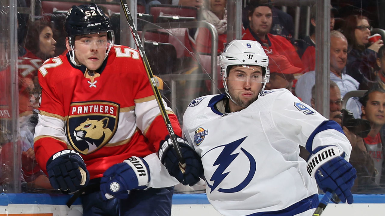 SUNRISE, FL - OCTOBER 30: Tyler Johnson #9 of the Tampa Bay Lightning checks MacKenzie Weegar #52 of the Florida Panthers into the boards behind the net at the BB&T Center on October 30, 2017 in Sunrise, Florida. The Lightning defeated the Panthers 8-5.