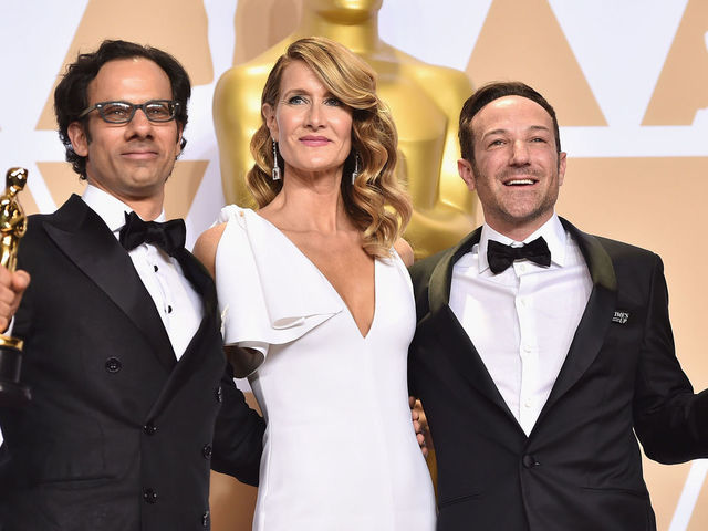 HOLLYWOOD, CA - MARCH 04: Actor Laura Dern (C) with producer Dan Cogan (L) and director Bryan Fogel, winners of the Best Documentary Feature for Icarus pose in the press room during the 90th Annual Academy Awards at Hollywood & Highland Center on March 4, 2018 in Hollywood, California.