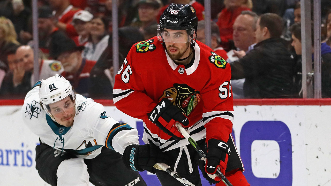 CHICAGO, IL - FEBRUARY 23: Erik Gustafsson #56 of the Chicago Blackhawks looks to pass under pressure from Justin Braun #61 of the San Jose Sharks at the United Center on February 23, 2018 in Chicago, Illinois.