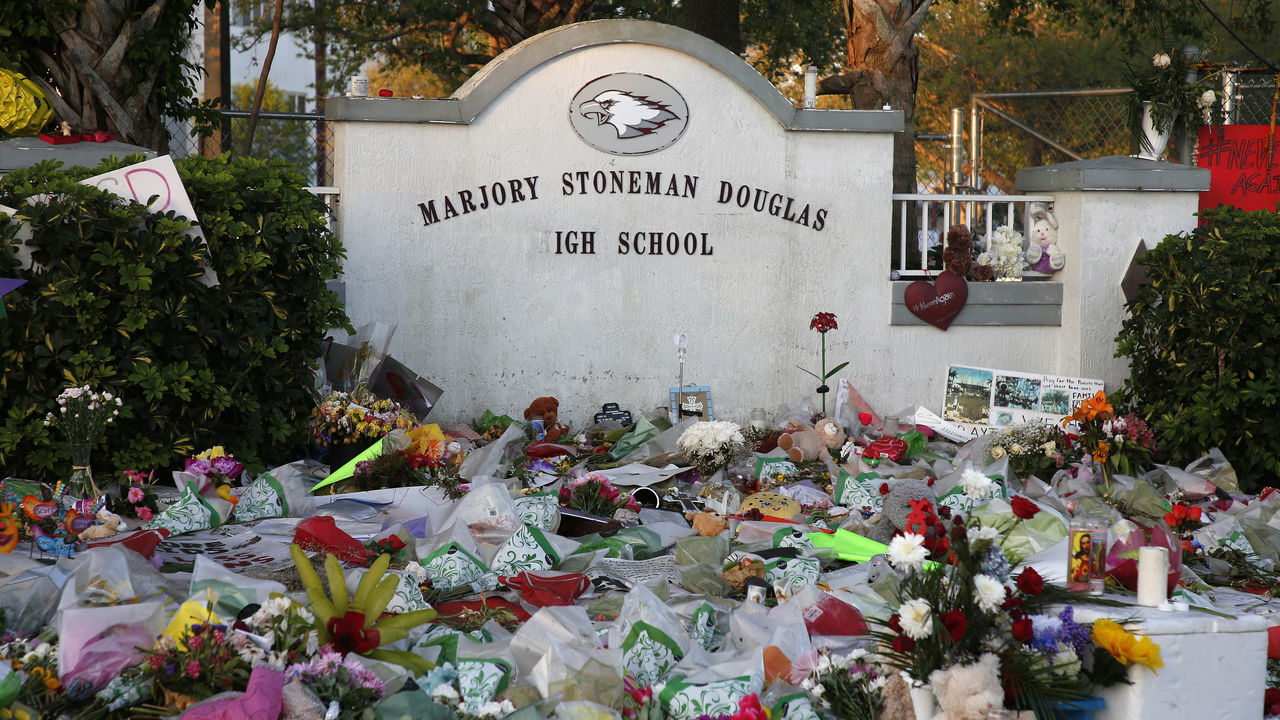 Flowers, candles and mementos sit outside one of the makeshift memorials at Marjory Stoneman Douglas High School in Parkland, Florida on February 27, 2018. Florida's Marjory Stoneman Douglas high school will reopen on February 28, 2018 two weeks after 17 people were killed in a shooting by former student, Nikolas Cruz, leaving 17 people dead and 15 injured on February 14, 2018. / AFP PHOTO / RHONA WISE