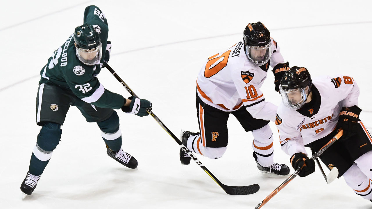 PRINCETON, NJ - NOVEMBER 24: Zach Whitecloud #32 of the Bemidji State Beavers, Jackson Cressey #10 and Max Becker #8 of the Princeton Tigers eye the puck during the first period at Hobey Baker Rink on November 24, 2017 in Princeton, New Jersey. Princeton defeated Bemidji State 4-1.