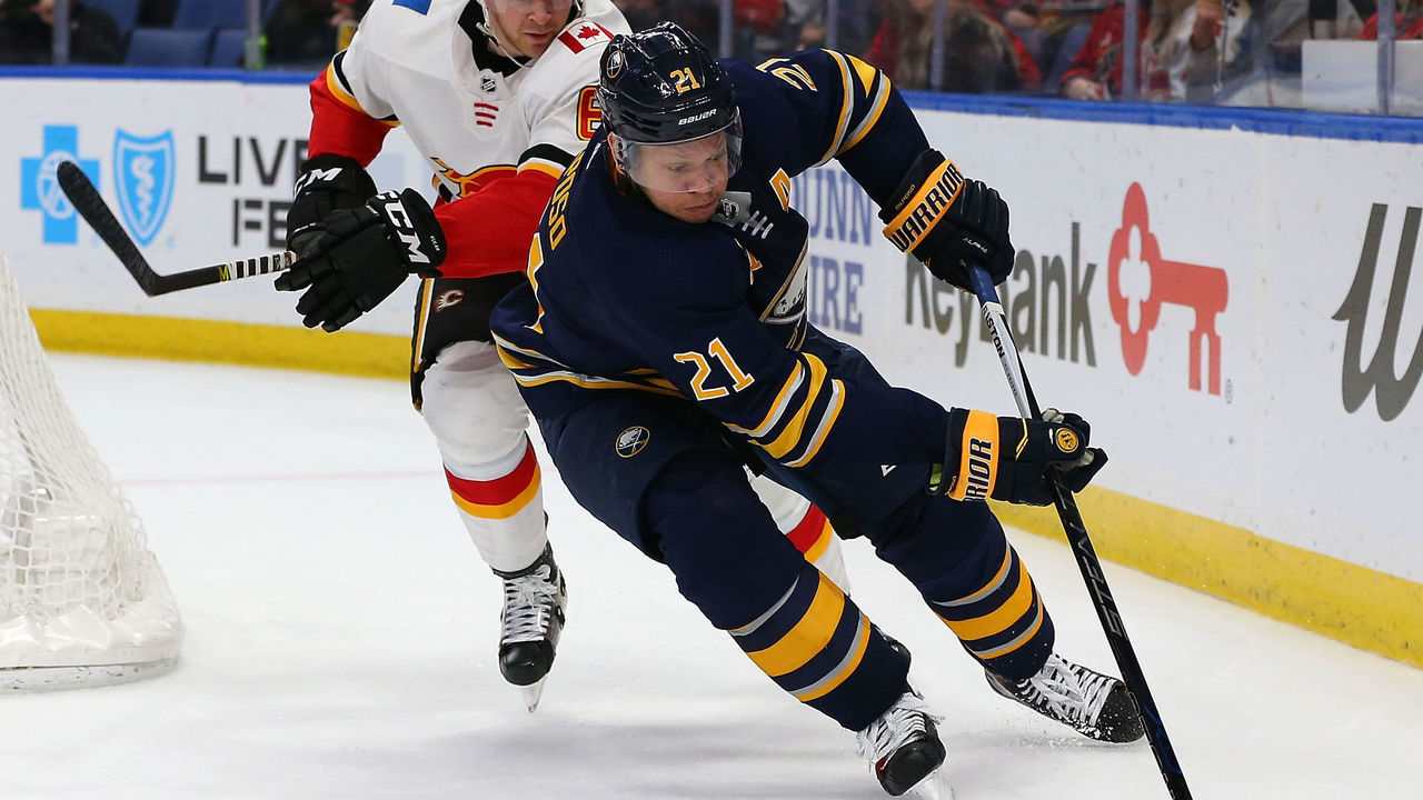 BUFFALO, NY - MARCH 7: Kyle Okposo #21 of the Buffalo Sabres take the puck behind the net as Brett Kulak #61 of the Calgary Flames pursues during the second period at KeyBank Center on March 7, 2018 in Buffalo, New York.