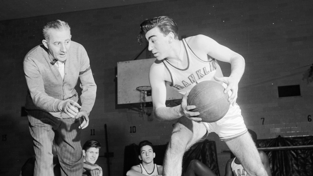 circa 1948: A coach checks the footwork of a basketball player.