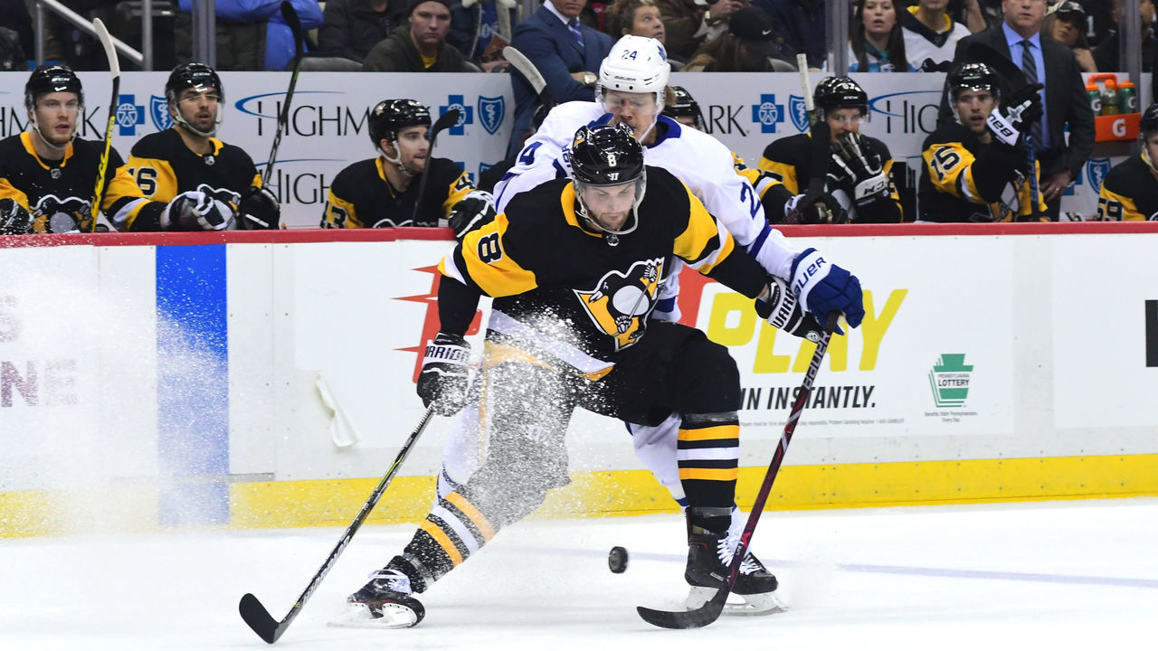 PITTSBURGH, PA - FEBRUARY 17: Brian Dumoulin #8 of the Pittsburgh Penguins fights for the puck against Kasperi Kapanen #24 of the Toronto Maple Leafs at PPG PAINTS Arena on February 17, 2018 in Pittsburgh, Pennsylvania.