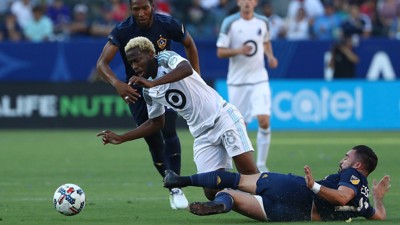 CARSON, CA - OCTOBER 15: Romain Alessandrini #7 of the Los Angele Galaxy tackles Kevin Molino #18 of Minnesota United FC in the first half during the MLS game at StubHub Center on October 15, 2017 in Carson, California.
