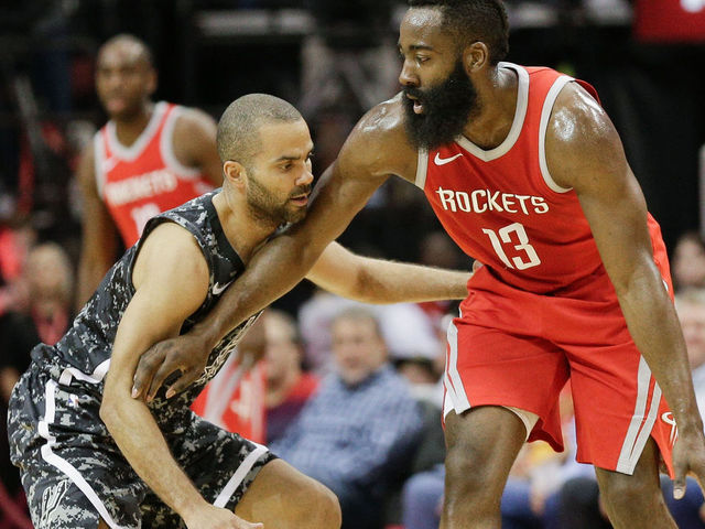 HOUSTON, TX - MARCH 12: James Harden #13 of the Houston Rockets holds off Tony Parker #9 of the San Antonio Spurs at Toyota Center on March 12, 2018 in Houston, Texas.