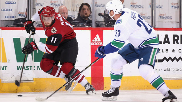 GLENDALE, AZ - FEBRUARY 25: Brendan Perlini #11 of the Arizona Coyotes skates the puck past Alexander Edler #23 of the Vancouver Canucks during the first period of the NHL game at Gila River Arena on February 25, 2018 in Glendale, Arizona. The Canucks defeated the Coyotes 3-1