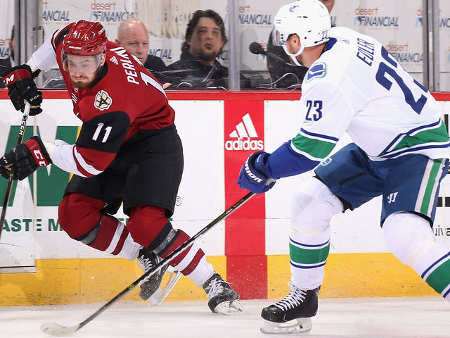 GLENDALE, AZ - FEBRUARY 25: Brendan Perlini #11 of the Arizona Coyotes skates the puck past Alexander Edler #23 of the Vancouver Canucks during the first period of the NHL game at Gila River Arena on February 25, 2018 in Glendale, Arizona. The Canucks defeated the Coyotes 3-1