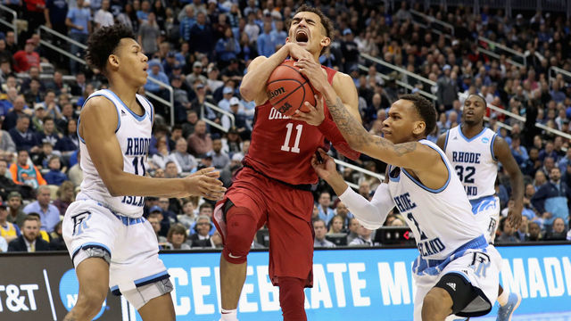 PITTSBURGH, PA - MARCH 15: Trae Young #11 of the Oklahoma Sooners reacts between Jeff Dowtin #11 and Fatts Russell #2 of the Rhode Island Rams in the second half of the game during the first round of the 2018 NCAA Men's Basketball Tournament at PPG PAINTS Arena on March 15, 2018 in Pittsburgh, Pennsylvania.
