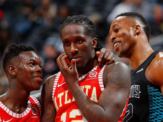 ATLANTA, GA - JANUARY 31: Dennis Schroder #17 and Taurean Prince #12 of the Atlanta Hawks converse next to Dwight Howard #12 of the Charlotte Hornets during the game at Philips Arena on January 31, 2018 in Atlanta, Georgia.