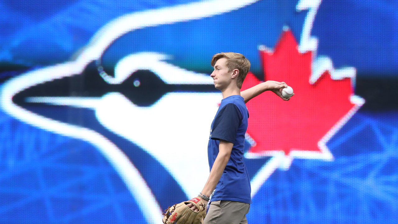 TORONTO, CANADA - AUGUST 14: Braden Halladay the son of former player Roy Halladay #32 of the Toronto Blue Jays plays catch in the outfield after the game before which his father was honored at the fortieth season celebrations before the start of MLB game action against the Houston Astros on August 14, 2016 at Rogers Centre in Toronto, Ontario, Canada.