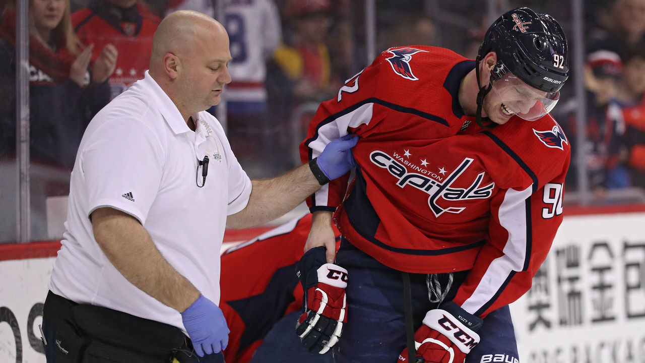 WASHINGTON, DC - MARCH 16: Evgeny Kuznetsov #92 of the Washington Capitals is helped off of the ice after being injured against the New York Islanders during the second period at Capital One Arena on March 16, 2018 in Washington, DC.