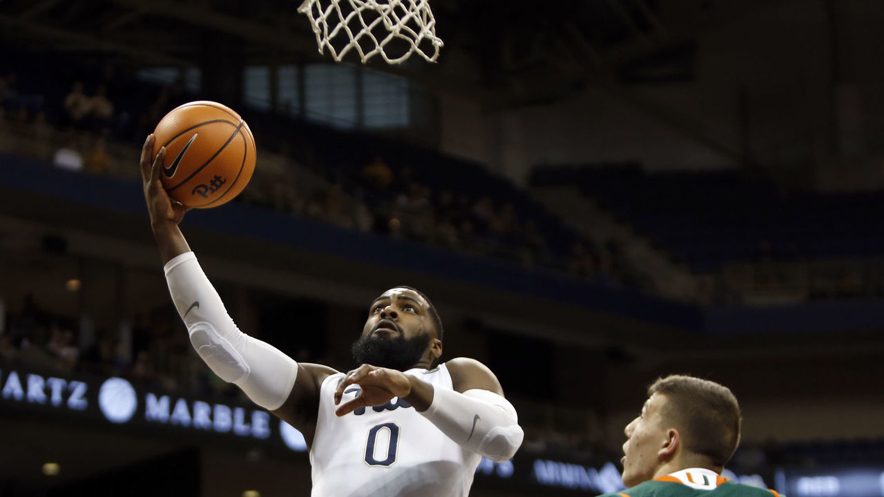 PITTSBURGH, PA - DECEMBER 30: Jared Wilson-Frame #0 of the Pittsburgh Panthers lays one in against Dejan Vasiljevic #1 of the Miami Hurricanes during the game at Petersen Events Center on December 30, 2017 in Pittsburgh, Pennsylvania.
