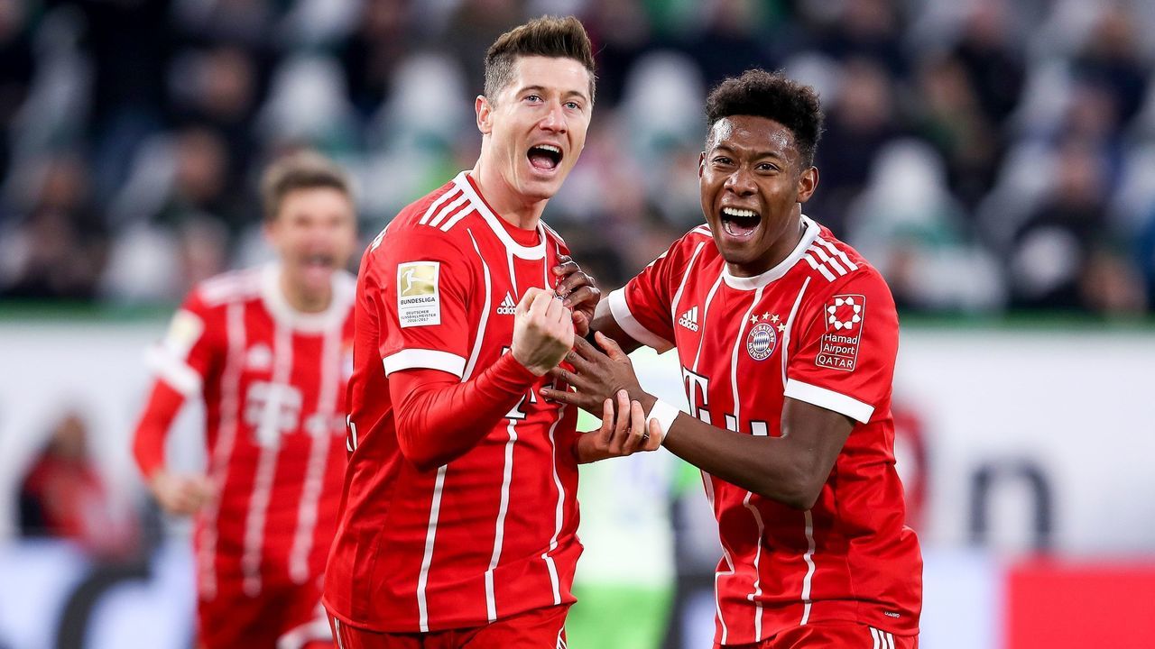 Bayern Munich's Polish forward Robert Lewandowski (L) celebrates with Bayern Munich's Austrian midfielder David Alaba (R) after scoring his team's second goal during the German first division Bundesliga football match between VfL Wolfsburg and FC Bayern Munich on February 17, 2018 in Wolfsburg. / AFP PHOTO / Ronny Hartmann / RESTRICTIONS: DURING MATCH TIME: DFL RULES TO LIMIT THE ONLINE USAGE TO 15 PICTURES PER MATCH AND FORBID IMAGE SEQUENCES TO SIMULATE VIDEO. == RESTRICTED TO EDITORIAL USE == FOR FURTHER QUERIES PLEASE CONTACT DFL DIRECTLY AT + 49 69 650050
