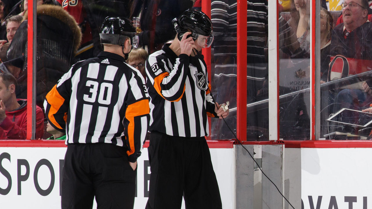 OTTAWA, ON - MARCH 9: Referees Kendrick Nicholson #30 and Mike Hasenfratz #27 get ready to review a goal from a coach's challenge during a game between the Ottawa Senators and the Calgary Flames at Canadian Tire Centre on March 9, 2018 in Ottawa, Ontario, Canada. *** Local Caption ***