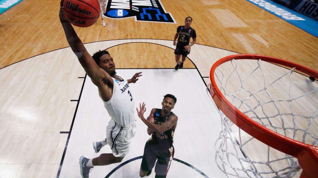 NASHVILLE, TN - MARCH 18: Quentin Goodin #3 of the Xavier Musketeers dunks the ball over Braian Angola #11 of the Florida State Seminoles during the second half in the second round of the 2018 Men's NCAA Basketball Tournament at Bridgestone Arena on March 18, 2018 in Nashville, Tennessee.