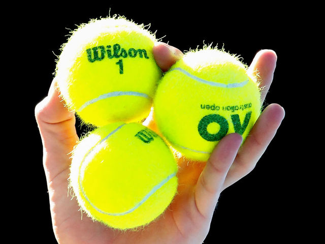 MELBOURNE, AUSTRALIA - JANUARY 22: Marton Fucsovics of Hungary holds tennis balls as he serves in his fourth round match against Roger Federer of Switzerland on day eight of the 2018 Australian Open at Melbourne Park on January 22, 2018 in Melbourne, Australia.