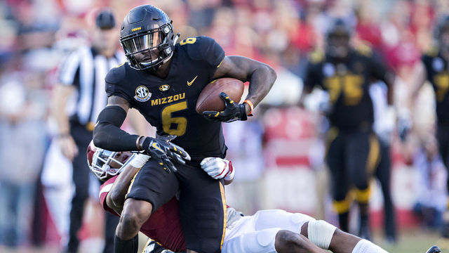 FAYETTEVILLE, AR - NOVEMBER 24: J'Mon Moore #6 of the Missouri Tigers runs the ball and is grabbed from behind by Henre' Toliver #5 of the Arkansas Razorbacks at Razorback Stadium on November 24, 2017 in Fayetteville, Arkansas. The Tigers defeated the Razorbacks 48-45.