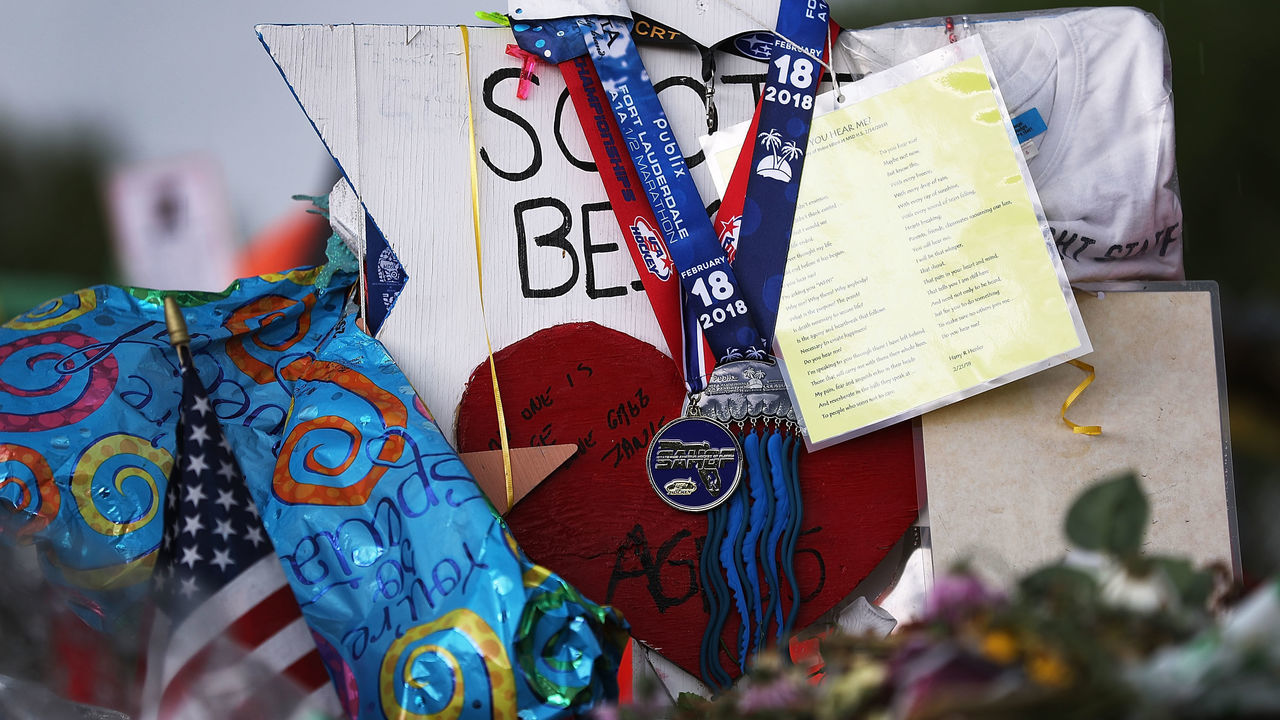 PARKLAND, FL - MARCH 07: The state championship medals for the Marjory Stoneman Douglas High School Eagles hockey team hang from a cross at a memorial in front of the school dedicated to victims of the February 14 mass shooting on March 7, 2018 in Parkland, Florida. The team won the champsionship 11 days after the shooting that claimed 17 lives.