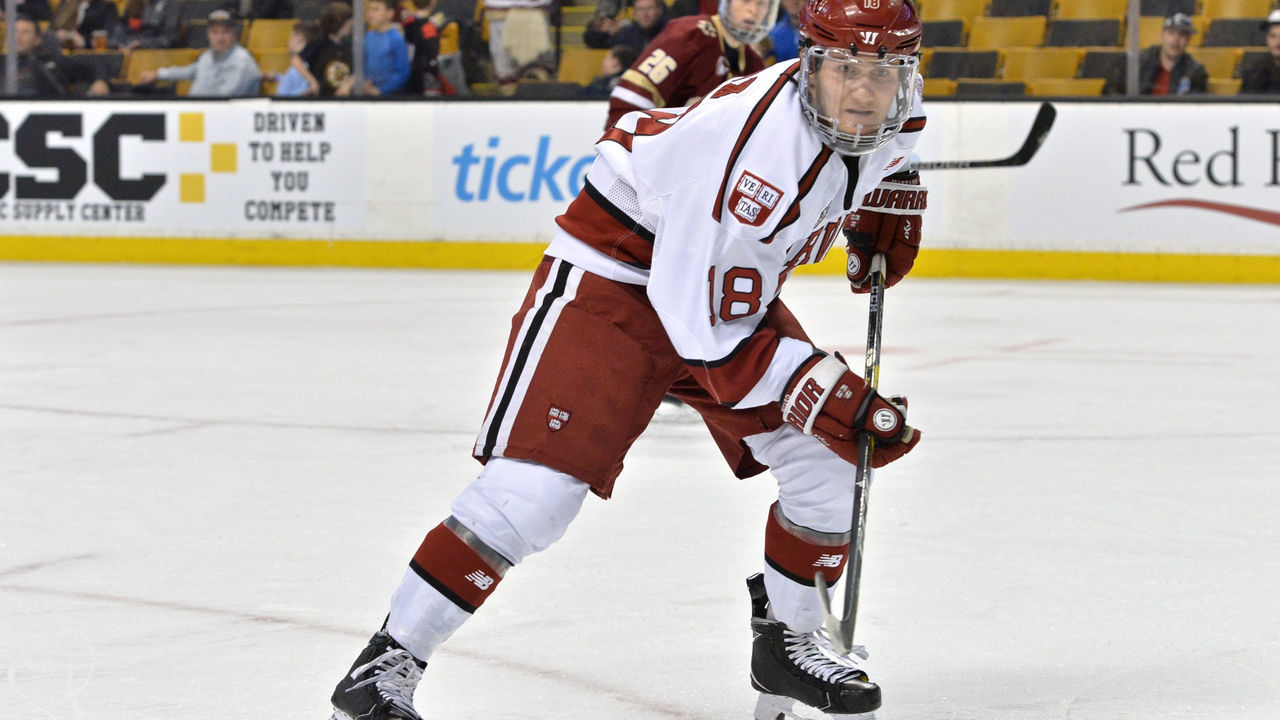BOSTON, MA - FEBRUARY 12: Harvard Crimson defenseman Adam Fox (18) keeps a close eye on the puck in the corner. During the Harvard University Crimson game against the Boston College Eagles at TD Garden on February 12, 2018 in Boston, MA.