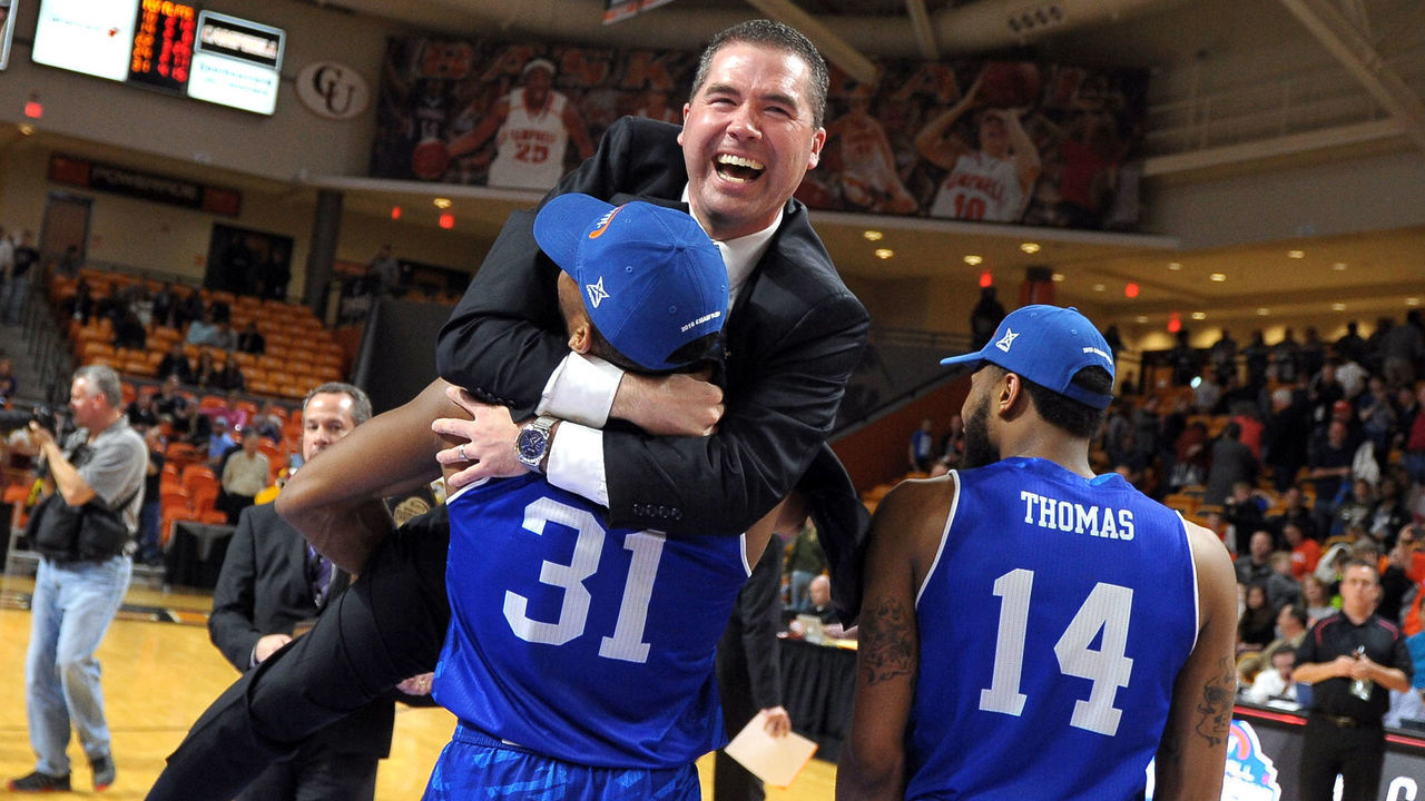 BUIES CREEK, NC - MARCH 06: Head coach Nick McDevitt of the North Carolina-Asheville Bulldogs celebrates with Sam Hughes #31 and Ahmad Thomas #14 following their 77-68 victory against the Winthrop Eagles during the championship game of the 2016 Big South Basketball Tournament at Pope Convocation Center on March 6, 2016 in Buies Creek, North Carolina.